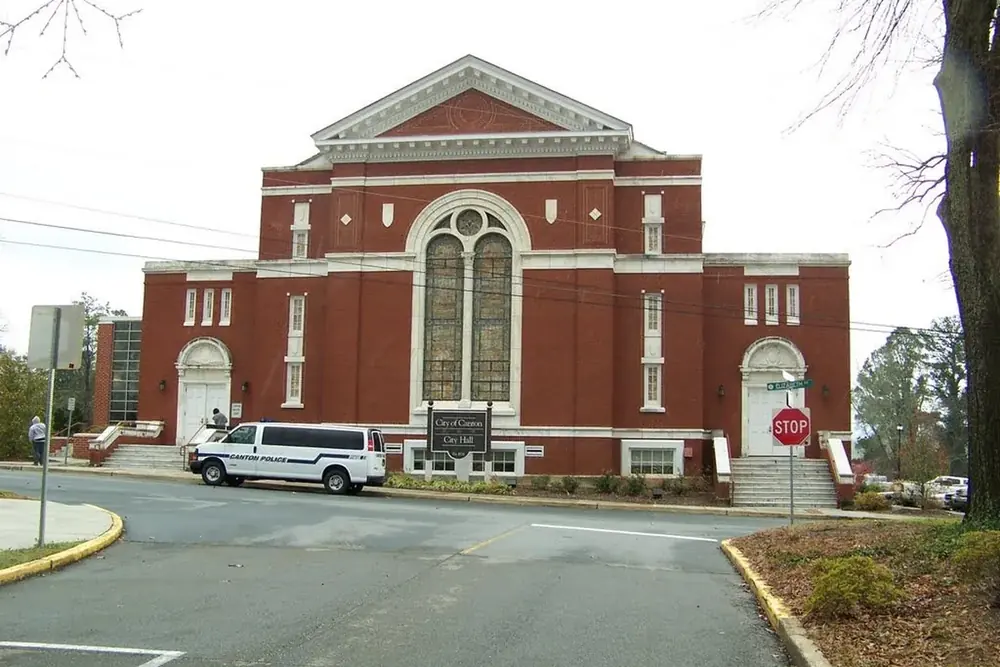 Canton City Hall, a red brick building with tall arched windows and white trim, in Canton, Georgia