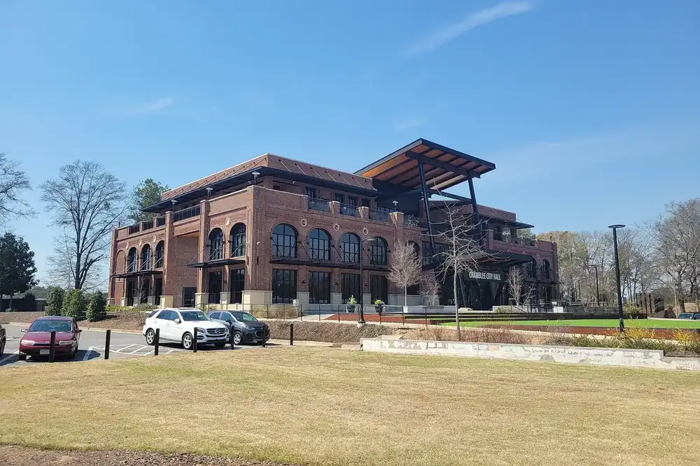 Chamblee City Hall, a modern brick building with arched windows, on a grassy lot in Chamblee, Georgia