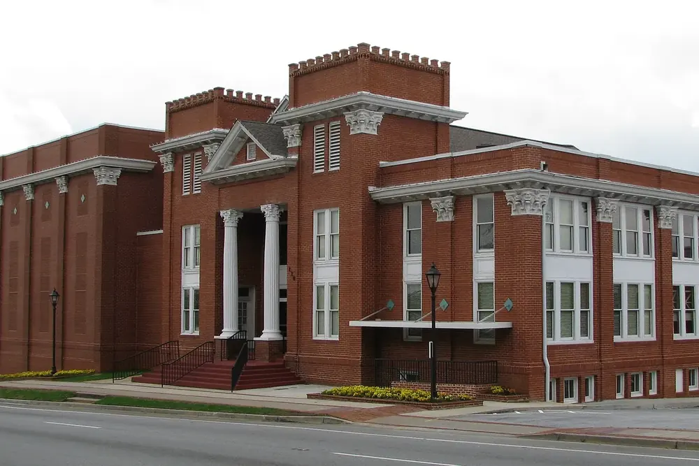 Historic red brick building with white columns and a parapet in downtown Lawrenceville, Georgia