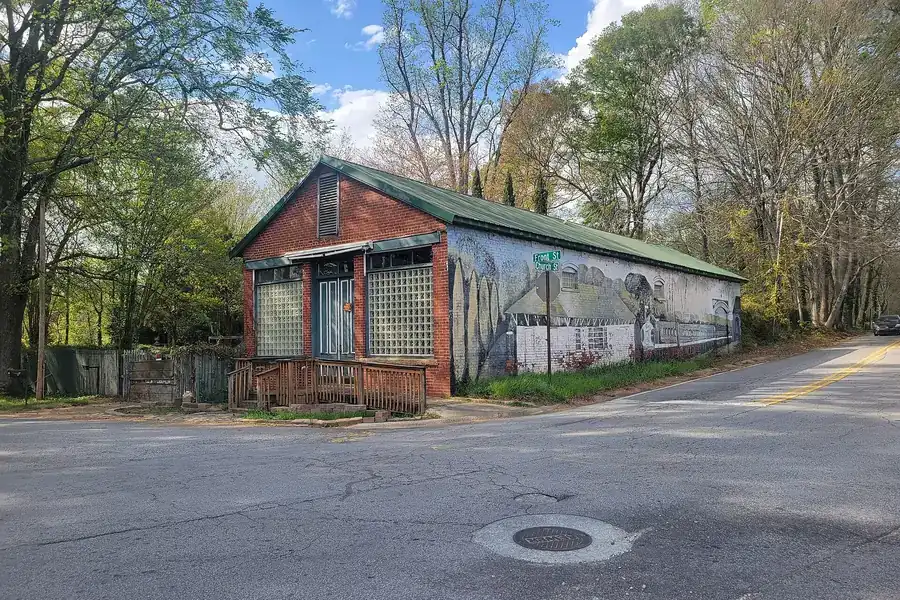 Old brick building with a painted side mural at a street corner in Mableton, Georgia
