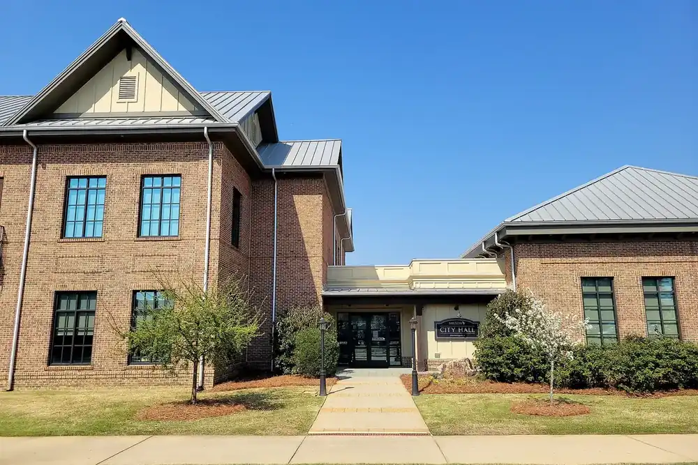 Milton City Hall, a two-story brick building with metal roofs and a walkway, in Milton, Georgia